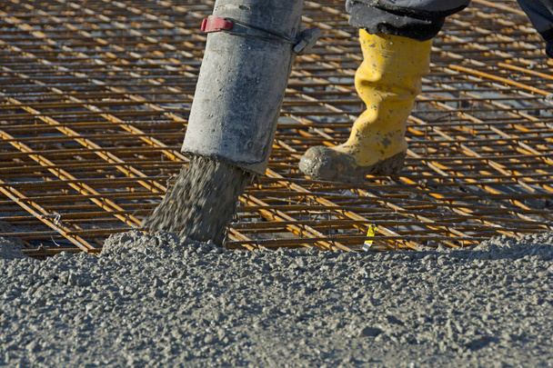 Trabajador de la construcción vierte hormigón en la barra de refuerzo con bomba de hormigón - Foto, Imagen