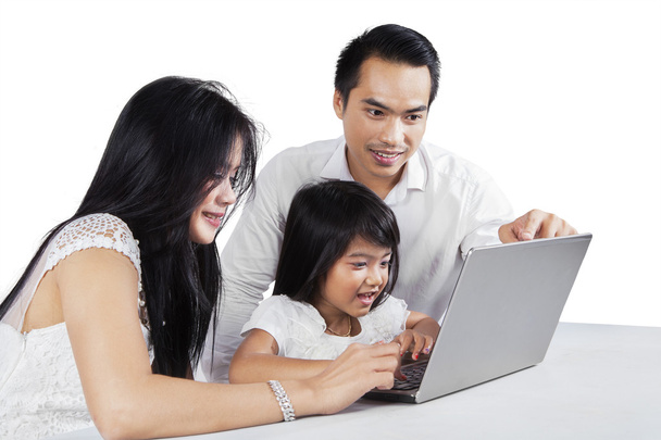 Happy parents using laptop with their child - Foto, immagini