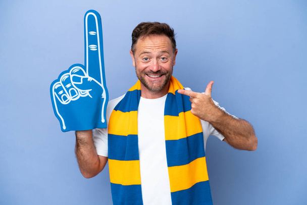 Middelbare leeftijd Kaukasische sport fan man geïsoleerd op blauwe achtergrond geven van een duim omhoog gebaar - Foto, afbeelding