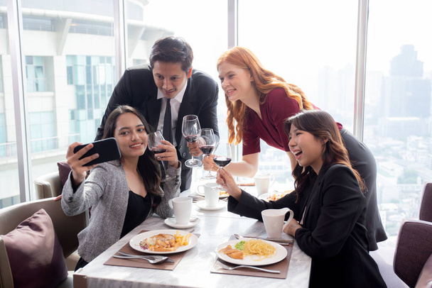 Ευτυχισμένη ομάδα νέων επιχειρηματιών στο κόμμα γιορτάζουν την επιτυχία selfie λήψη μιας φωτογραφίας με φίλους μαζί στο εστιατόριο, τη φιλία και την κοινωνική συνάδελφο, πληρούν τους φίλους και την έννοια της κοινότητας. - Φωτογραφία, εικόνα