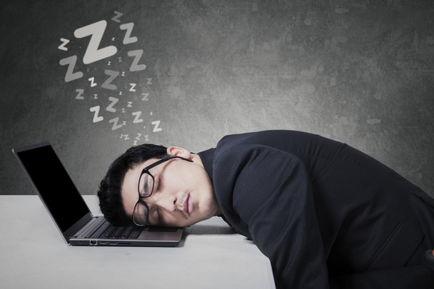 Hombre de negocios durmiendo en el ordenador portátil
 - Foto, imagen