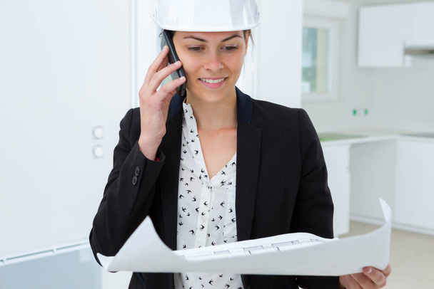 beatiful woman engineer with plans papers on building site - Foto, Bild