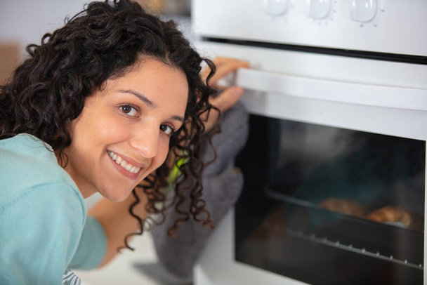 woman cooks food in the oven - Φωτογραφία, εικόνα