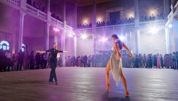 Pár tanečníků předvádí latinský tanec na velkém profesionálním pódiu. - Fotografie, Obrázek