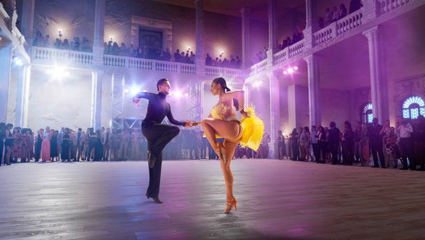 Para tancerzy wykonuje taniec latynoski na dużej scenie zawodowej. - Zdjęcie, obraz