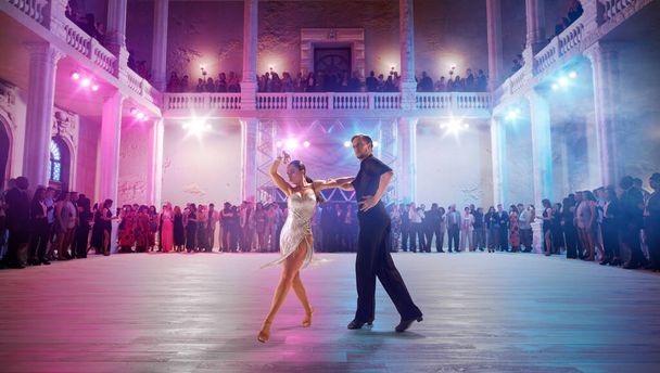 Пара танцюристів виконують латинський танець на великій професійній сцені
. - Фото, зображення