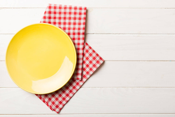 Top näkymä värillinen tausta tyhjä pyöreä keltainen levy pöytäliina ruokaa. Tyhjä ruokalaji lautasliina tilaa oman suunnittelun. - Valokuva, kuva