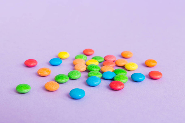 Mucchio di deliziose caramelle colorate dolci su sfondo colorato vista dall'alto. Arredo dolciario. - Foto, immagini