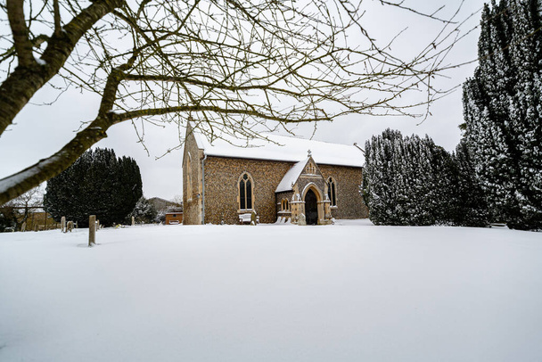 Iglesia de Todos los Santos en el pequeño pueblo de Sutton en el campo británico, está totalmente cubierto de nieve profunda durante una rara tormenta de nieve en el Reino Unido - Foto, imagen