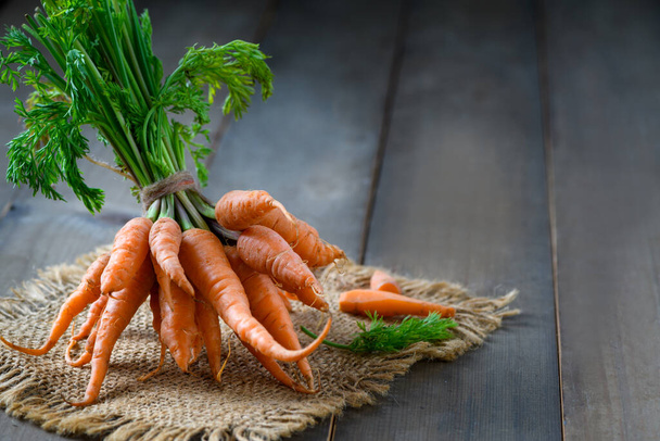Fresh Baby carrots on wood background, High Beta Carotene and help the body have immunity against colds. Prevent cancer and diseases related to bone, skin and eyes - Photo, Image