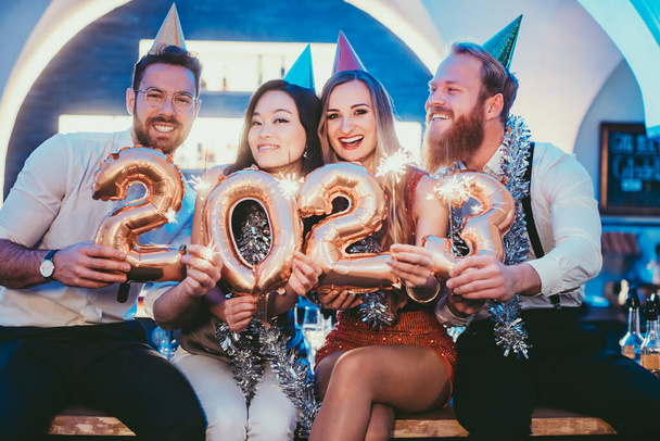 women and men celebrating the new year 2023 with wine - Foto, Imagen