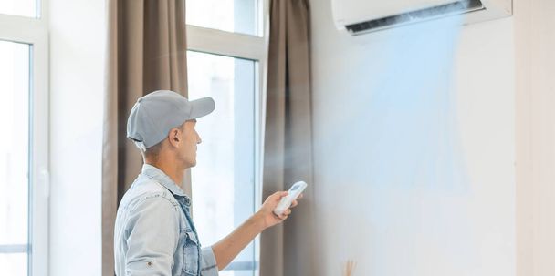 Professionelle reife Meister installiert die Klimaanlage im Raum - Foto, Bild