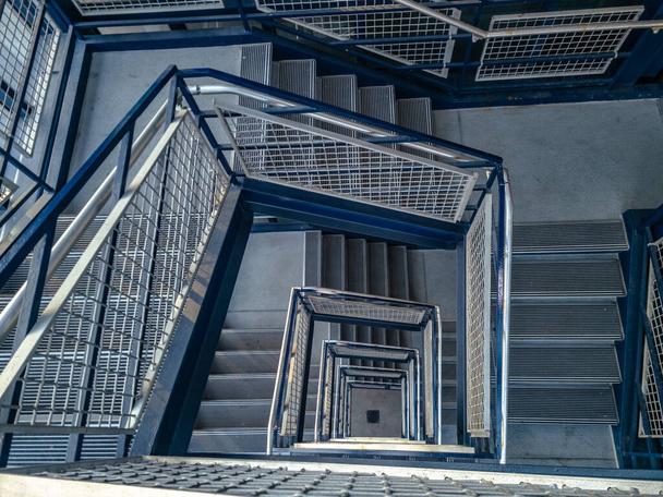Escalera en un garaje. Los escalones de la escalera están hechos de hormigón y los pasamanos son metálicos y pintados de azul. Situado en la gran terraza azul en el aeropuerto de Detroit Metro en Romulus, Michigan - Foto, imagen