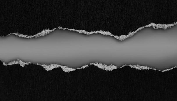 Papier noir déchiré sur fond gris - Photo, image