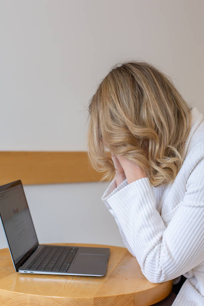 Mooi meisje freelancer gevoel moe en gestrest tijdens het gebruik van een laptop en werken op afstand van huis. Zakenvrouw op kantoor is depressief..  - Foto, afbeelding