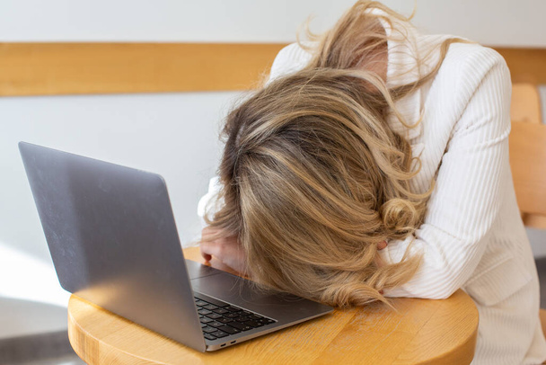 Güzel kız bilgisayarını kullanırken ve uzaktan çalışırken kendini yorgun ve stresli hissediyor. Ofisteki iş kadını depresyonda..  - Fotoğraf, Görsel