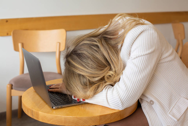 Schöne Freiberuflerin, die sich müde und gestresst fühlt, während sie einen Laptop benutzt und von zu Hause aus arbeitet. Geschäftsfrau im Büro ist depressiv.  - Foto, Bild