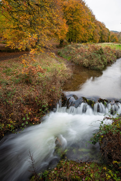 Długa ekspozycja wodospadu w Rabbers Bridge w Exmoor National Park jesienią - Zdjęcie, obraz