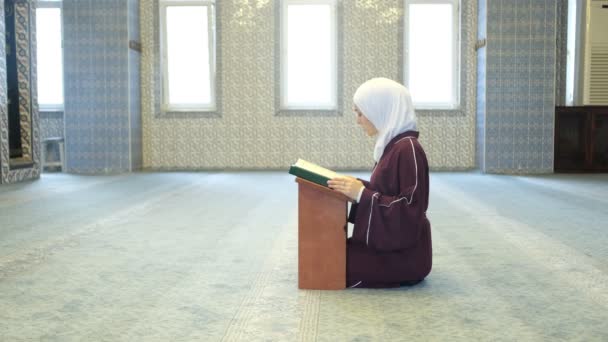 Hijabi Woman Quran Απαγγελία, ισλαμική λατρεία στο τζαμί, μουσουλμάνοι ζουν islam, ασιατικό μουσουλμανικό κορίτσι κάθεται στα γόνατά της απαγγέλλοντας το Κοράνι - Πλάνα, βίντεο
