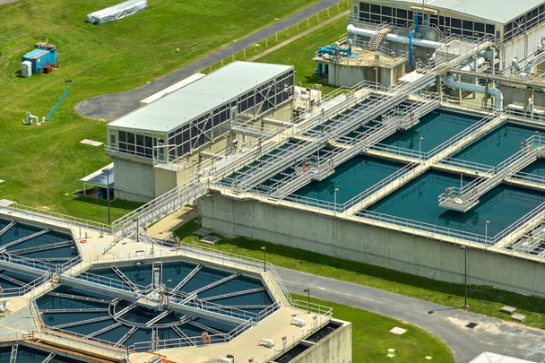 Aerial view of modern water cleaning facility at urban wastewater treatment plant. Purification process of removing undesirable chemicals, suspended solids and gases from contaminated liquid. - Fotoğraf, Görsel