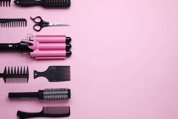 Flat lay composition with modern hair triple curling iron on pink background, space for text - Фото, зображення
