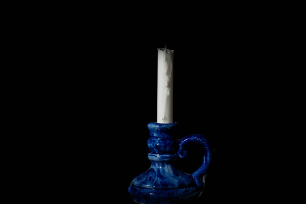 黒の背景にろうそくのついた青い燭台。高品質の写真 - 写真・画像