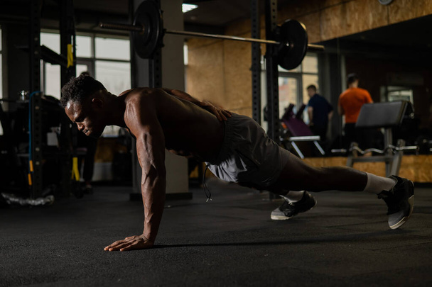 Africano americano fazendo um braço empurrar para cima no ginásio - Foto, Imagem