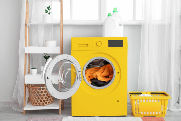 Modern sárga mosógép a fürdőszoba belsejében mosással - Fotó, kép