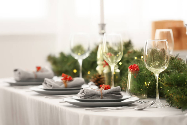 Apparecchiatura tavola di Natale con rami di abete e sorbo in sala da pranzo, primo piano - Foto, immagini