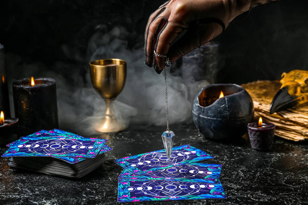 Fortune teller segítségével inga és tarot kártyák olvasni jövő sötét háttér - Fotó, kép