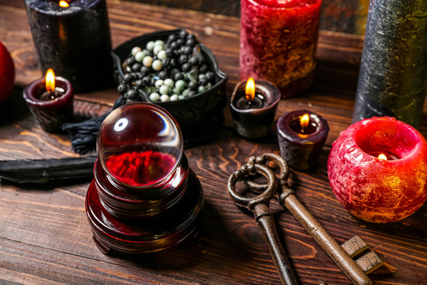 Хрустальный шар и волшебные атрибуты гадалки на деревянном столе - Фото, изображение