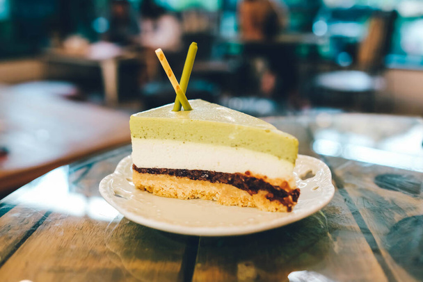 Πράσινο τσάι κέικ στο ξύλινο τραπέζι και blured φόντο. - Φωτογραφία, εικόνα