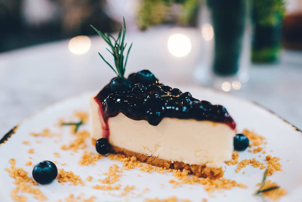 A piece of blueberry cheesecake on the table. - Zdjęcie, obraz