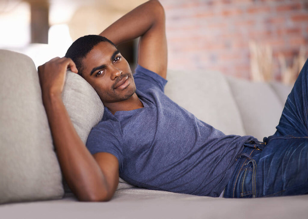 Enjoying his downtime. a handsome young man relaxing at home - 写真・画像