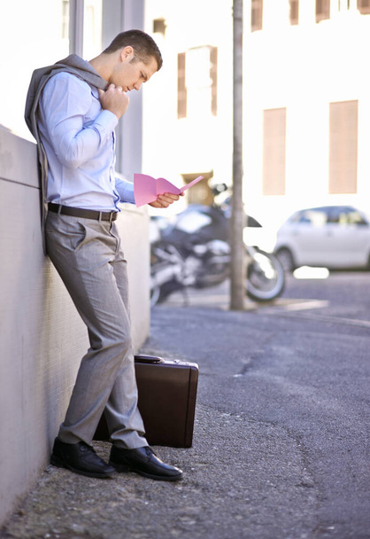 Vor einer ungewissen Zukunft. ein Geschäftsmann mit einem rosafarbenen Zettel, der sein Arbeitsverhältnis beendet - Foto, Bild