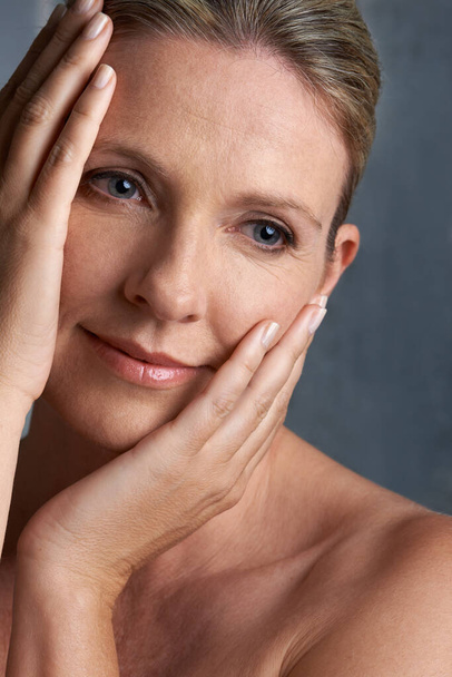 Save your skin. Cropped studio shot of a beautiful mature woman touching her face - 写真・画像