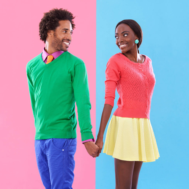 Due piselli in un baccello. Studio girato di una giovane coppia in piedi su uno sfondo colorato - Foto, immagini