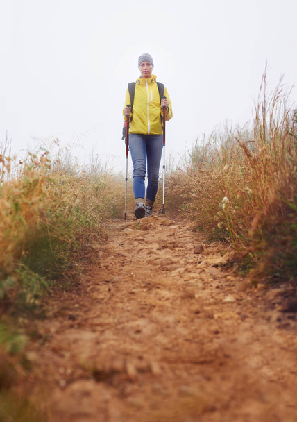 Peloton tutkimusmatkailija. Matalan kulman näkymä naispatikoijasta kävelemässä vaelluspolkua pitkin - Valokuva, kuva