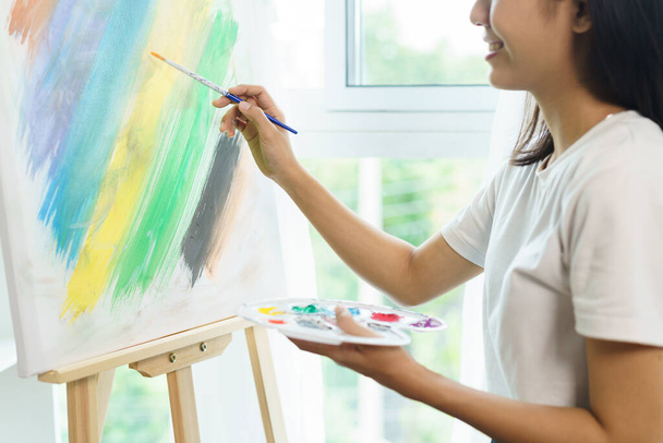 El concepto de arte, artista femenina asiática utilizando el pincel para crear una obra maestra sobre lienzo en el estudio de arte. - Foto, Imagen