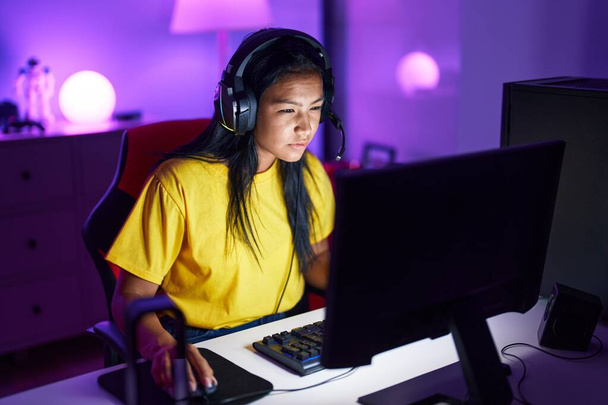 Mladý krásný latinsky žena streamer hrát videohry pomocí počítače v herně - Fotografie, Obrázek