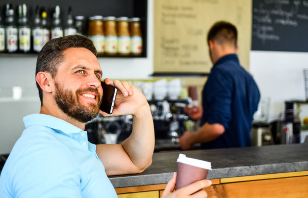 Coffee break concept. Glad to hear you. Coffee take away option for busy people. Man mobile conversation cafe barista background. Drink coffee while waiting. Man smartphone order coffee in cafe. - Fotoğraf, Görsel
