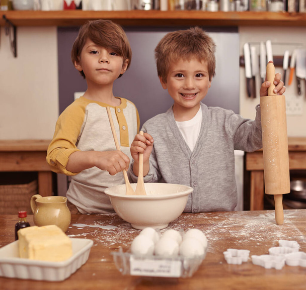 Vamos a ser los mejores panaderos de la historia. dos hermanos jóvenes horneando en la cocina - Foto, imagen