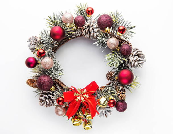 Decorative festive Christmas wreath. Wreath with red and golden christmas toys on white background - Photo, Image