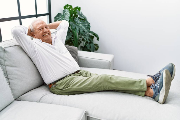 Senior man smiling confident sitting on sofa at home - Valokuva, kuva