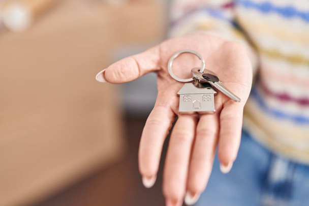 Joven mujer caucásica sosteniendo llave en nuevo hogar - Foto, Imagen
