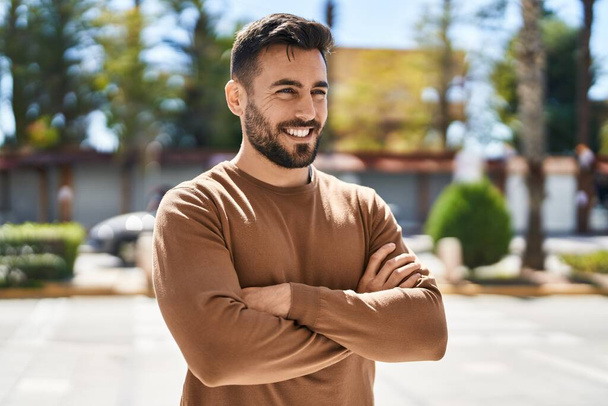 Young hispanic man smiling confident standing with arms crossed gesture at park - Foto, Imagem