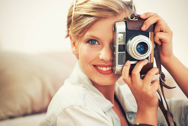 A treinar para as minhas próximas férias. Uma jovem mulher tirando fotos com sua câmera em casa - Foto, Imagem