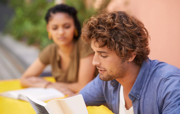 Los frutos de la educación son dulces. Una foto de estudiantes universitarios sentados al aire libre con material de lectura - Foto, imagen