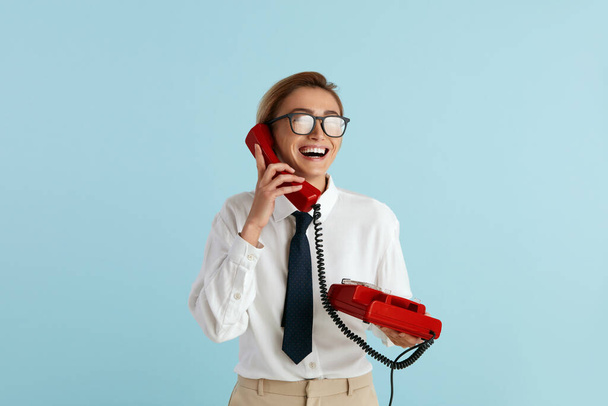 Businesswoman Talking Landline Telephone. Caucasian Woman Speaking on Smartphone, Smiling, Using Landline Phone for Communication. Modern Person Having Fun and Speaking on Call  - Fotografie, Obrázek