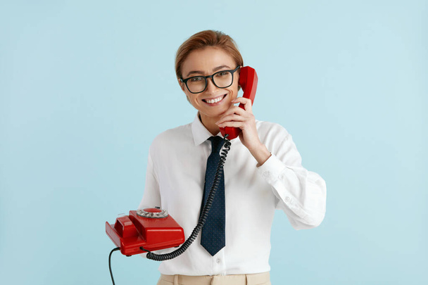 Businesswoman Talking Landline Telephone. Caucasian Woman Speaking on Smartphone, Smiling, Using Landline Phone for Communication. Modern Person Having Fun and Speaking on Call  - Photo, image